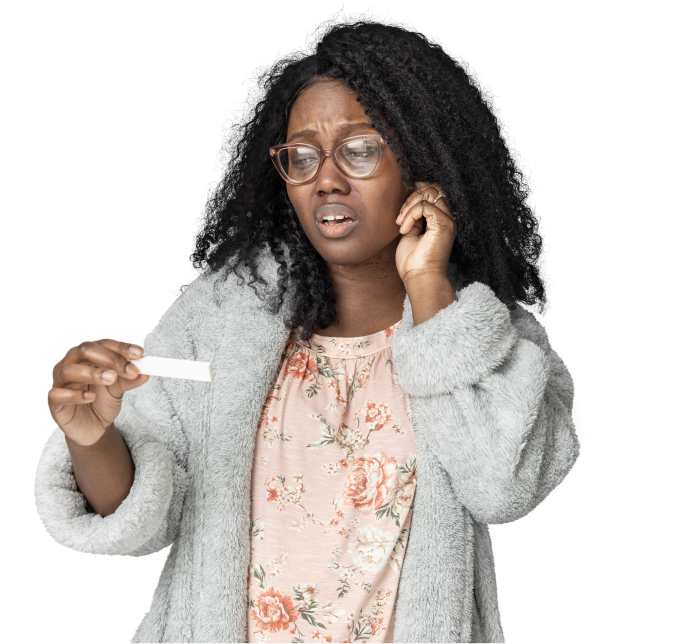 A woman in a fleece jacket looking at a positive COVID-19 test.