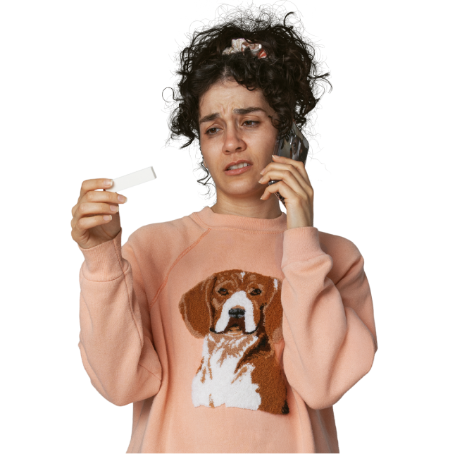A woman holding a positive COVID-19 test while on the phone.